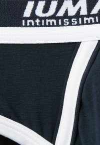 Czarna bawełniana bielizna z białą elastyczną talią z logo "PUMA". Tkanina ma gładką fakturę i minimalne detale szwów.