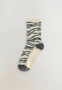 Čarape s uzorkom koje prikazuju dizajn zebra pruga u crnoj i bež boji, s akcentom u svijetloplavoj boji. Prst je tamnosiv. Meki pleteni materijal.