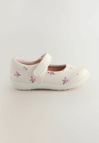 Scarpa Mary Jane bianca con motivo floreale in rosa e grigio, dotata di una fascetta in velcro, punta arrotondata e suola in gomma testurizzata.