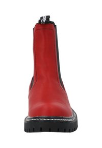 Botín de tobillo rojo de cuero con paneles elásticos laterales negros, puntera redonda, suela negra gruesa y detalles de costura de contraste alrededor de la suela.