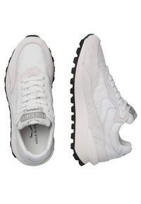 Weiße Schnürsneaker mit einem Obermaterial aus strukturiertem Leder und Wildleder, kontrastierender schwarzer Gummisohle sowie Logo-Akzenten an Zunge und Ferse.