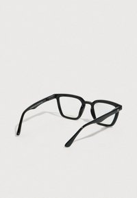 Μαύρα πλαστικά γυαλιά με γεωμετρικό σκελετό, διαυγή φακούς και λεπταίνει σταδιακά βραχίονες. Διαθέτουν λεία υφή και ελάχιστα μεταλλικά διακοσμητικά στοιχεία.