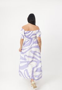 Abito lungo con una stampa zebrina viola e bianca. Design senza spalle, corpino arricciato e maniche a sbuffo. Texture del tessuto liscia.