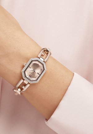 Rose gold octagonal watch with a blush dial, embellished with crystal accents, and a linked bracelet band.