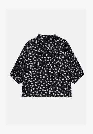 Juoda gėlių bliuskutė su trumpomis pūkuotomis rankovėmis, kaklo raišteliu ir mažų baltų gėlių raštu. Pagaminta iš lengvos medžiagos.