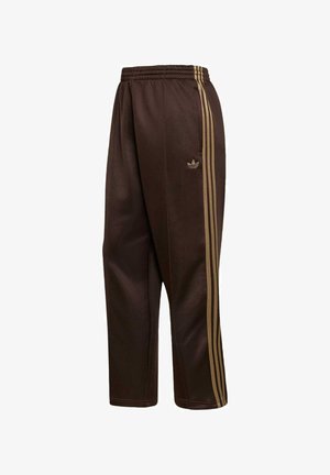 Braune Adidas Trainingshose mit elastischem Bund und goldenen Drei-Streifen-Details an den Seiten, mit dem Adidas-Trefoil-Logo auf einem Bein.