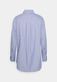 Light blue long-sleeve shirt with a button-down collar, back pleat detail, and button cuffs. Made from woven fabric with a textured finish.