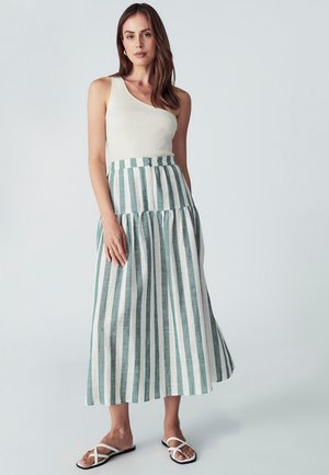 Witte geribde tanktop, gecombineerd met een lange rok in afwisselend teal en witte strepen, met een verzamelde taille en platte sandalen.