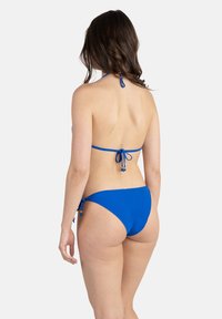 Bikini bleu avec un col halter et un design à nouer dans le dos. Le bas a des liens sur les côtés et est taille basse, le tout fait d'un tissu lisse.