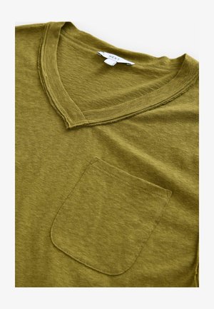 T-shirt vert olive en v, fabriqué en tissu doux, avec une poche avant et des détails à bords bruts le long de l'encolure.