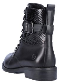 Botte noire à la cheville avec une base en cuir lisse et un panneau en imitation serpent brillant. Dotée d'un avant à lacets et d'un accent boucle sur le côté. Talon bas.