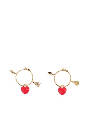 Pendientes de aro dorados con forma de flechas y colgantes de corazón rojo, uno con detalles de cristales en la cola de la flecha.