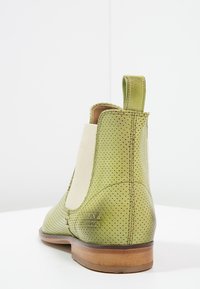 Botín Chelsea verde de cuero con diseño perforado, paneles laterales elásticos y suela de madera en tono marrón claro. Cuenta con una tira en la parte posterior.