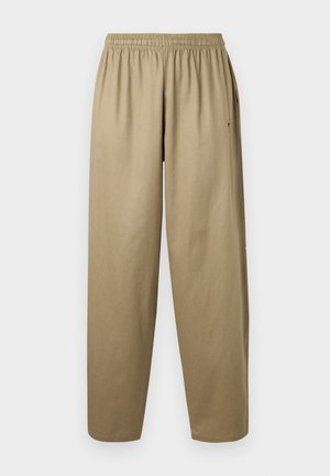 Pantalon kaki ample avec ceinture élastique et poches latérales, présenté sur un fond blanc uni.