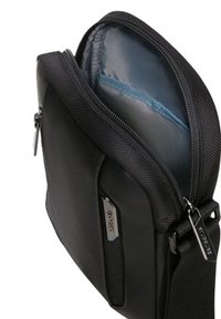 Borsa a messenger in nylon nero con apertura a zip, rivestimento interno blu, tasca laterale e dettagli in metallo sul tirazip. Texture liscia, forma compatta.