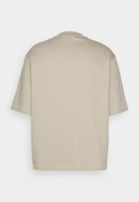 Beige katoenen t-shirt met een relaxed fit, korte mouwen en een ronde hals. Glad textuur, geen zichtbare patronen of accenten.