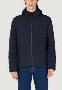 Giubbotto imbottito blu con motivo a righe orizzontali, cerniera frontale e cappuccio regolabile. Realizzato in materiale sintetico, leggero e caldo.