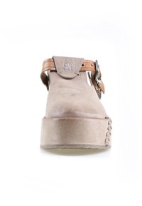 Chaussure à plateforme beige avec bride en cuir marron à la cheville et boucle en métal, détails cousus sur l'avant-pied, et inscription en relief "AS 98" sur le rabat supérieur.