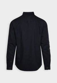 Chemise noire à manches longues avec un col standard, des poignets boutonnés et un ourlet incurvé. Fabriquée en tissu lisse, avec un design simple.