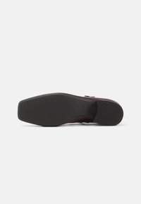 Sola de sapato bordeaux com um design liso e texturizado. Bico arredondado, salto mínimo e uma marcação subtil perto do arco. Sola exterior de borracha preta durável.