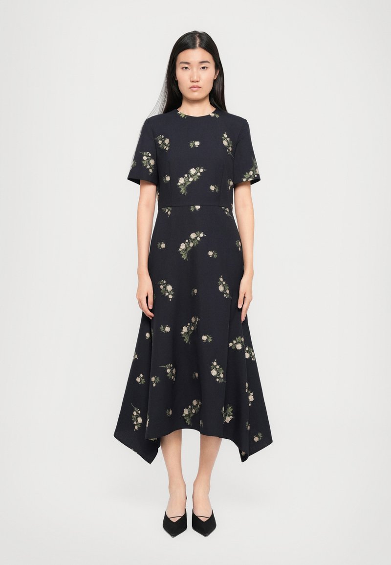 Robe noire à fleurs avec des manches courtes, dotée d'un corsage ajusté et d'un ourlet asymétrique évasé. Fleurs de couleur claire en accent partout.