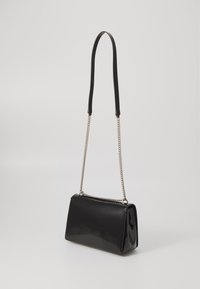 Black patent leather handbag with a rectangular shape, single black handle, and detachable silver chain strap, featuring smooth texture and clean lines.