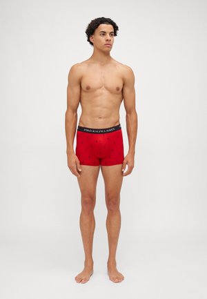Boxer de hombres rojos con una cintura negra que presenta el logo "POLO RALPH LAUREN" y pequeños logos bordados por toda la tela.