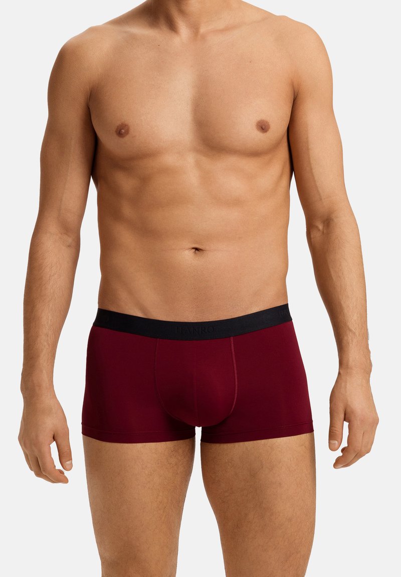 Boxer brevii borgogna con vestibilità aderente, realizzati in tessuto morbido. Vita nera con logo del marchio, texture liscia e senza dettagli extra.