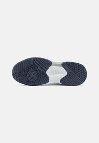 Shoe sole with a white midsole and a textured navy rubber outer sole. Features a circular grip pattern and hexagonal accents for traction.
