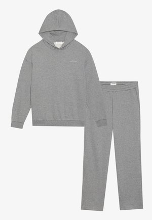 Completo di felpa e pantaloni in cotone grigio. La felpa presenta una tasca a marsupio e polsini a costine; i pantaloni hanno una vita elastica e tasche laterali.