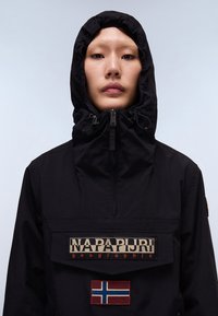 Giacca nera con cappuccio, dotata di chiusura a zip, grande tasca frontale, logo "NAPAPIJRI" e patch della bandiera norvegese sul davanti.