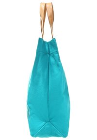 Turkos canvas-tygväska med två beigefärgade läderhandtag, med en triangulär botten och sydda detaljer för extra stadga.