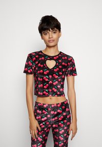 Top cropped preto com mangas curtas e um corte em forma de coração, apresentando padrões de cerejas vermelhas brilhantes e detalhes verdes por toda a peça.