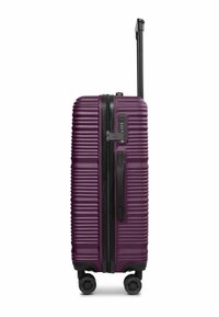 Valise rigide de couleur violet profond avec des rainures horizontales, fermeture éclair et poignée noires, serrure à code sur le côté, et quatre roues multidirectionnelles noires.