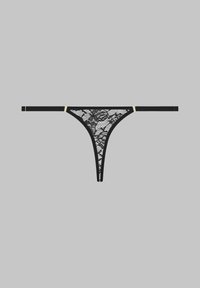 String noir en dentelle avec des motifs floraux, texture délicate et fines bretelles. Accentué par des éléments en or sur les côtés.