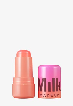 Blush en bâton de couleur corail avec une pointe arrondie. Le contenant est bicolore, rose et orange, avec la marque "Milk Makeup" en lettres en gras.