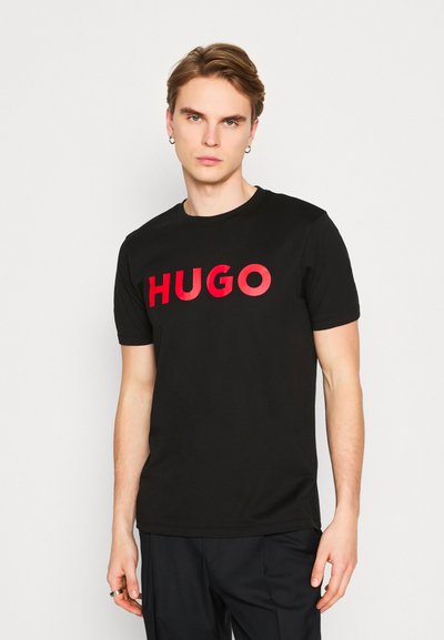 Черен памучен T-shirt с ярко червен логотип "HUGO" на гърдите. С кръгло деколте и къси ръкави с отпуснато прилягане.