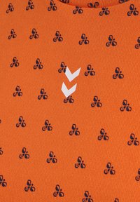 Pomarańczowa tkanina z powtarzającymi się małymi granatowymi czteropłatkowymi motywami kwiatowymi oraz dwoma białymi paskami typu chevron w pobliżu środka.