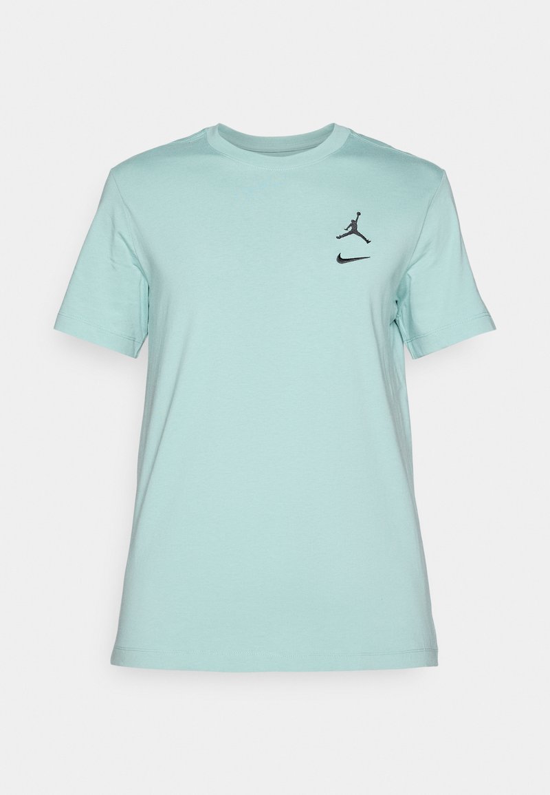 Camiseta de algodón azul claro con cuello redondo, que presenta los logotipos de Jordan y Nike en negro en la parte superior izquierda del pecho. Mangas cortas, textura suave.