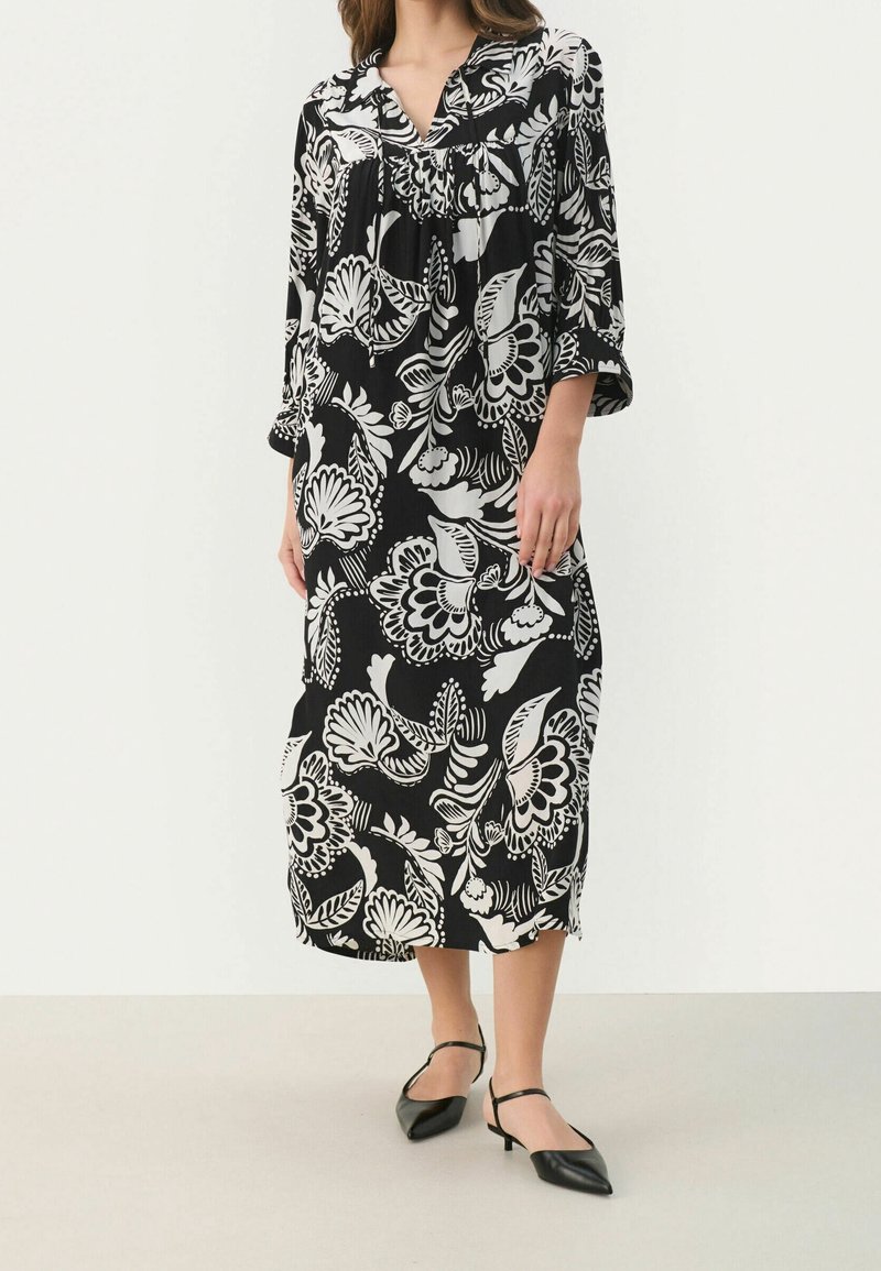 Vestido midi de estampado floral en blanco y negro con mangas tres cuartos, escote en V y corte relajado, hecho de tela ligera.