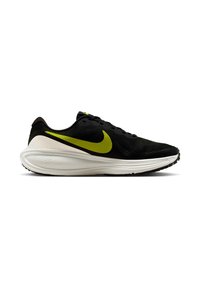 Mustat juoksukengät, joissa on verkkopinta, vihreä Nike-logo ja valkoinen pehmeä pohja. Varustettu nauhoilla ja ristikkäisellä mustalla ulkopohjalla pidon parantamiseksi.
