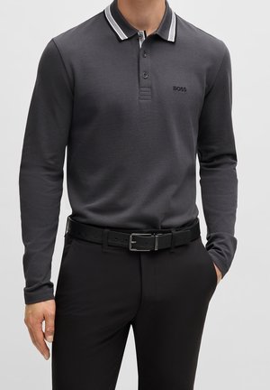 Koszula polo z długim rękawem w ciemnoszarym kolorze z kontrastującym kolorowym kołnierzykiem. Posiada logo na piersi oraz teksturowany materiał. Czarny pasek.