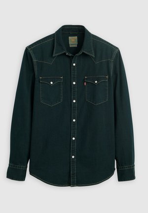 Dark green denim shirt with a pointed collar, two chest pockets, white buttons, and contrasting yellow stitching. Long sleeves with buttoned cuffs.