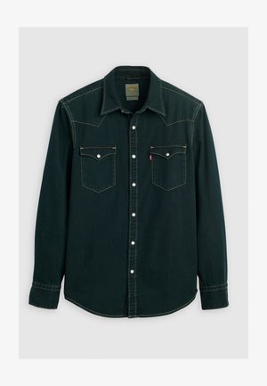 Dark green denim shirt with a pointed collar, two chest pockets, white buttons, and contrasting yellow stitching. Long sleeves with buttoned cuffs.