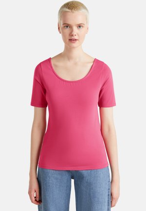 Camicia rosa a maniche corte realizzata in tessuto liscio ed elasticizzato, con scollo rotondo e silhouette aderente. Nessun motivo o dettaglio visibile.