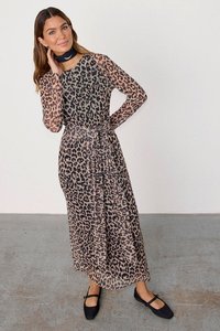 Maxi šaty s leopardím potiskem, dlouhými průhlednými rukávy, staženým pasem a splývavým materiálem. V kombinaci s jednoduchými černými balerínami.