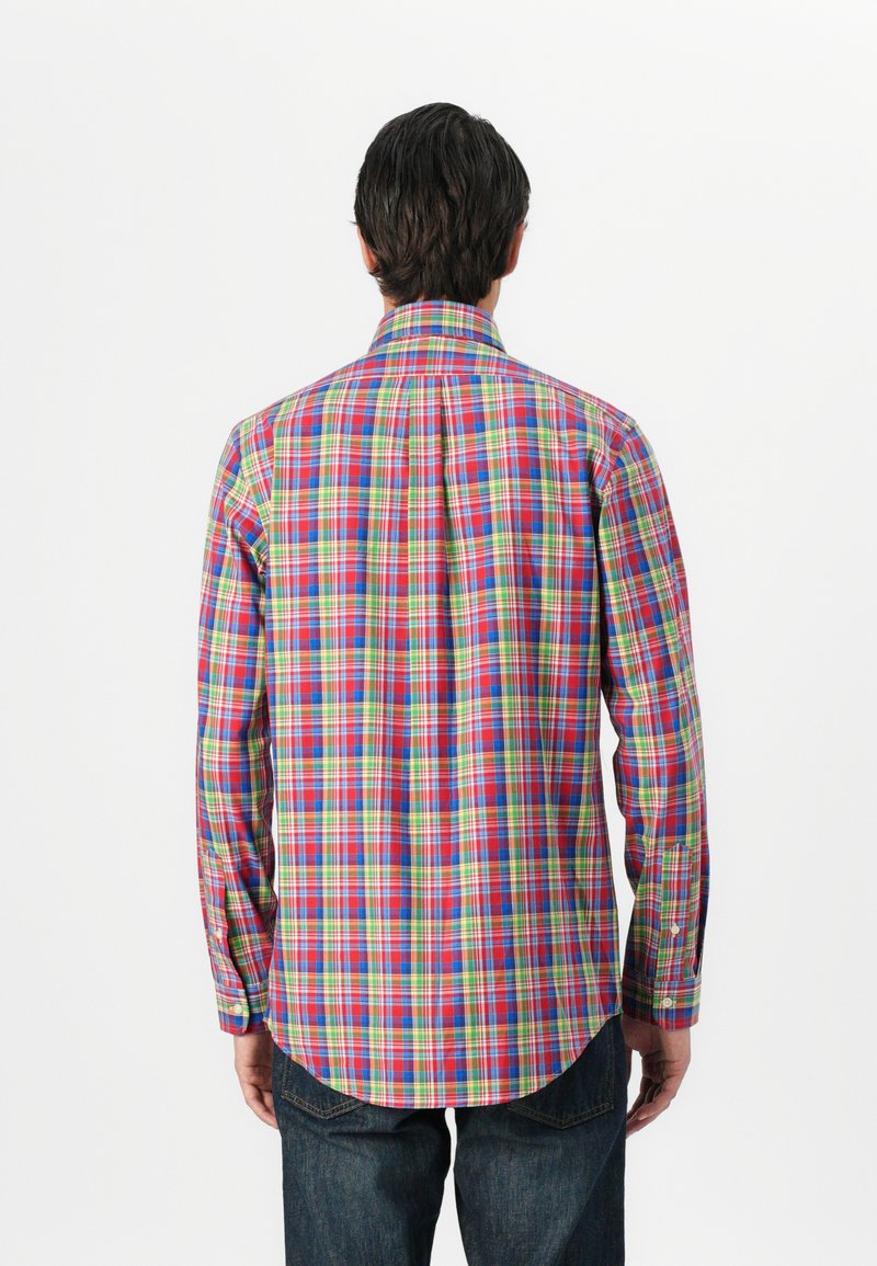 Koszula w wielokolorową kratę z niebieskimi, czerwonymi, zielonymi i żółtymi kwadratami. Długie rękawy z guzikami i klasyczny kołnierzyk. Materiał bawełniany.