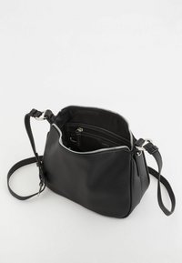 Czarna skórzana torba o teksturowanej powierzchni, zamek błyskawiczny i wewnętrzna kieszeń. Posiada regulowany pasek oraz srebrne okucia.