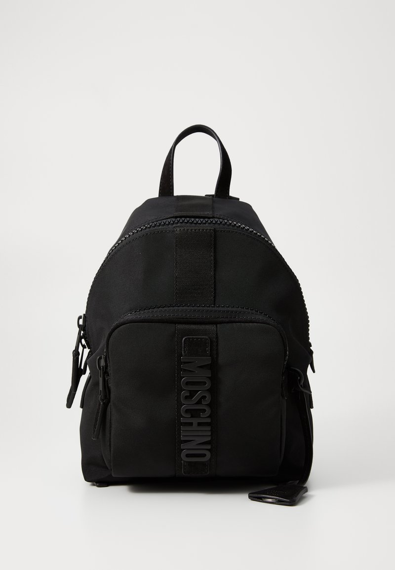 Fekete Moschino hátizsák elülső cipzáros zsebből, felső fogantyúból és logórészletből a zsebpanelen.