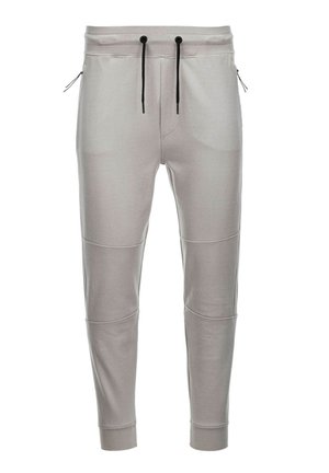 Lys grå joggingbukser lavet af blødt stof med elastisk talje, sorte snore, sidelommer med lynlås og ribbede manchetter ved anklerne.